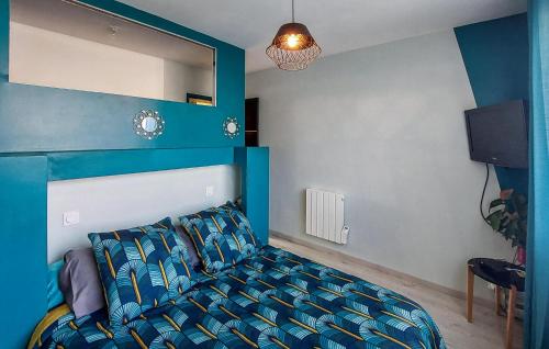 a bedroom with a bed and a blue wall at Awesome Home In Saint-Michel-Chef-Chef in Saint-Michel-Chef-Chef