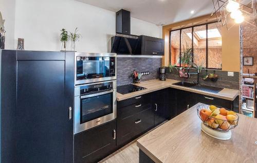 a kitchen with a black refrigerator and a bowl of fruit at Awesome Home In Saint-Michel-Chef-Chef in Saint-Michel-Chef-Chef
