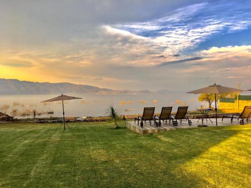 a group of chairs and umbrellas next to the water at Casa Bravía - Hotel·RV in San Luis Soyatlán