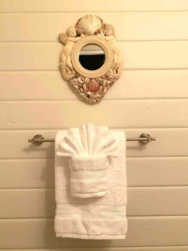 a towel rack with a mirror on a wall at North Shore Garden Suite in Haleiwa