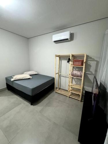 een kamer met een bed en een televisie. bij 2- Studio Prox Uel e catuai c/ar in Londrina
