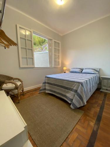 a bedroom with a bed and a window at Casa da Varanda Próximo Centro in Petrópolis