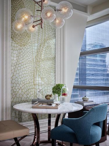a dining room with a table and blue chairs at Rosewood Bangkok in Bangkok
