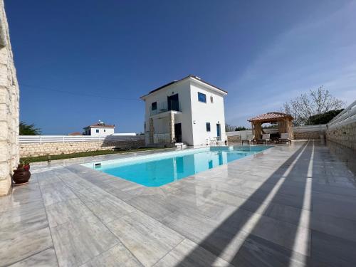 a swimming pool in front of a building at Jomavi Beach Eco-Villa in Polis Chrysochous