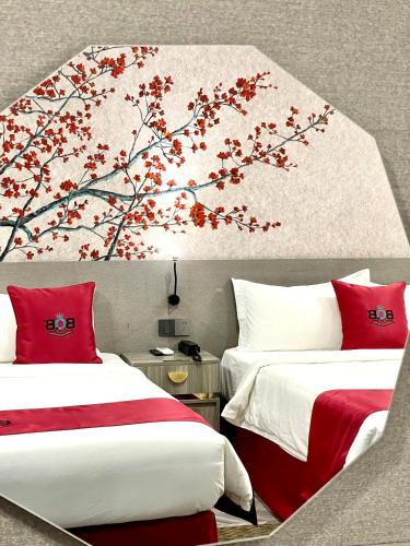 a bedroom with two beds and a tree mural at B.O.B Hotel in Cao Lãnh