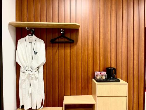 a white robe is hanging on a wooden wall at B.O.B Hotel in Cao Lãnh