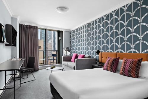 um quarto de hotel com uma cama e um sofá em Mantra Sydney Central em Sydney