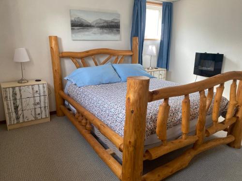 ein Schlafzimmer mit einem Holzbett mit einem Holzrahmen in der Unterkunft 316 Patricia Street Accommodation in Jasper