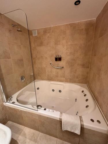 y baño con bañera y aseo. en Alto Andino Hotel en Ushuaia