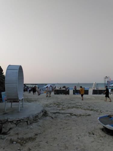 plaża z krzesłem i ludzie na plaży w obiekcie Homestay Hang Câu w mieście An Vĩnh Phướng