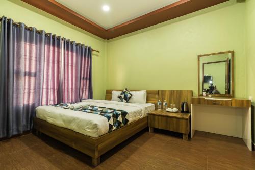 1 dormitorio con 1 cama grande y espejo en Sisai Park Village en Chitwan