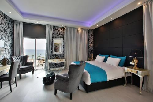 a bedroom with a bed and a desk and chairs at The Josephine Boutique Hotel in Larnaka