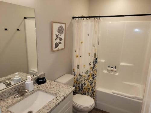 a bathroom with a sink and a toilet and a shower at The Prairie at Coventry Rows in Omaha