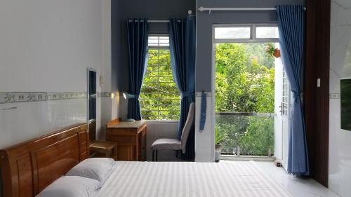 1 dormitorio con cama, ventana y escritorio en Sunny Homestay Quy Nhơn en Quy Nhon
