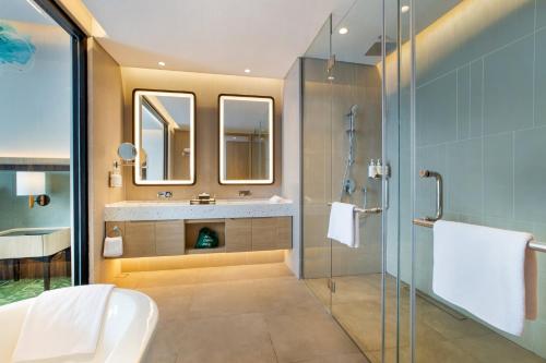 a bathroom with a sink and a glass shower at Holiday Inn Lampung Bukit Randu, an IHG Hotel in Bandar Lampung