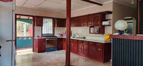 a large kitchen with red cabinets and an open door at Fenix Hotel & Hostel in Utila