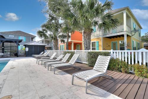 a row of white chairs in front of a house at Casa de Flip Flops in Rockport