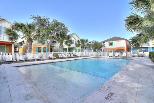 a swimming pool with chairs and palm trees at Casa de Flip Flops in Rockport