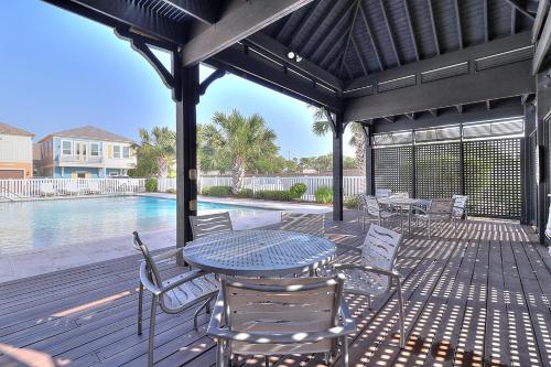 a patio with a table and chairs and a pool at Casa de Flip Flops in Rockport