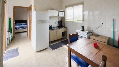 Bella Praia apartamento Golfinho في باسو دي توريس: مطبخ صغير مع طاولة وثلاجة