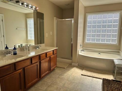 a bathroom with a tub and a sink and a bath tub at Grand Lux Getaway in Lexington