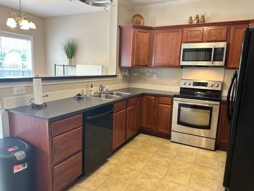 a kitchen with wooden cabinets and a stainless steel appliances at Grand Lux Getaway in Lexington