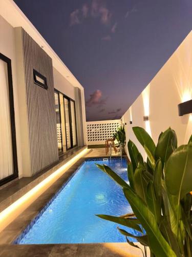 ein großer Pool in der Mitte eines Gebäudes in der Unterkunft Brand New Two-Bedroom Villa with rice field views. in Tanah Lot