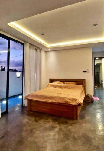 ein Schlafzimmer mit einem Bett und einem großen Fenster in der Unterkunft Brand New Two-Bedroom Villa with rice field views. in Tanah Lot