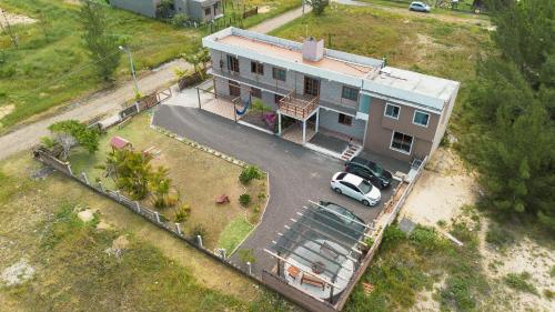 una vista aerea di una casa con un'auto parcheggiata di fronte di Bella Praia apartamento Estrela do mar a Passo de Torres
