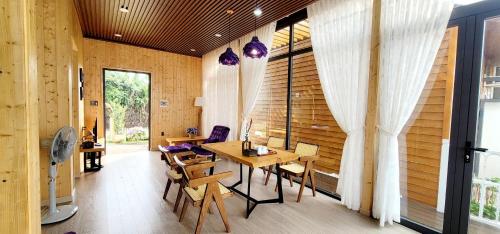 Zimmer mit einem Tisch, Stühlen und einem Fenster in der Unterkunft La Fleur Glamping in Minrong Sekang