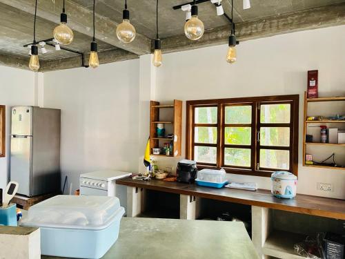 a kitchen with a table and a refrigerator and some lights at HOLY VILLA 4rooms, 5beds, 6baths, 1KCH, 1LR riverside private villa in Kampot