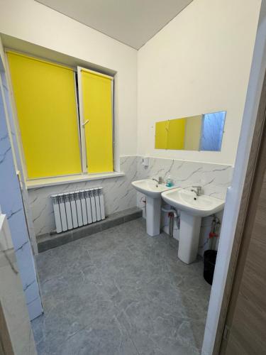 a bathroom with two sinks and two mirrors at Abay Hostel in Almaty