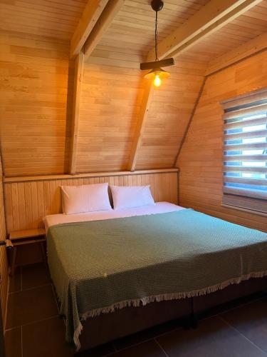 1 dormitorio con 1 cama en una habitación de madera en Sapanca yeşilvadi 2+1 sıcak havuz,jakuzi,göl manzr, en Sakarya