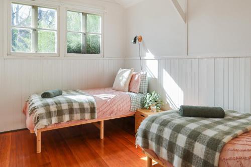 um quarto com 2 camas e uma janela em Pink Cabin By Host on the Coast em Barwon Heads