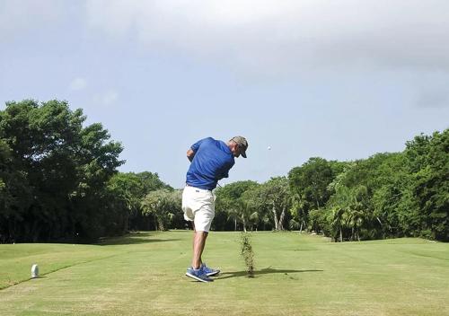 a man is standing on a golf course at Beachfront Breathtaking Views Puerto Aventuras in Puerto Aventuras