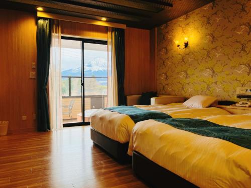 御殿場的住宿－Hotel Square FujiGotemba，酒店客房设有两张床和窗户。