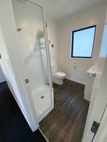 a bathroom with a shower and a toilet at Soul Sanctuary, with outdoor bath in Raglan