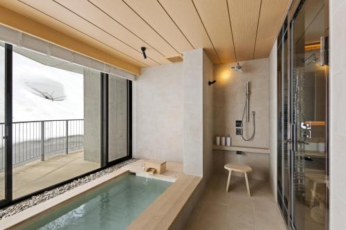 a bathroom with a swimming pool and a shower with a window at YAMAKEI Residences in Niseko