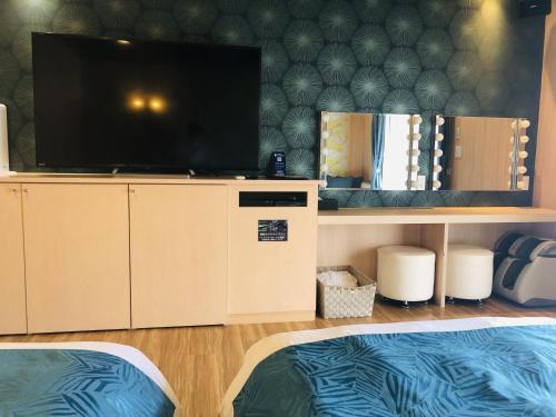 a room with two beds and a flat screen tv at Hotel Square FujiGotemba in Gotemba