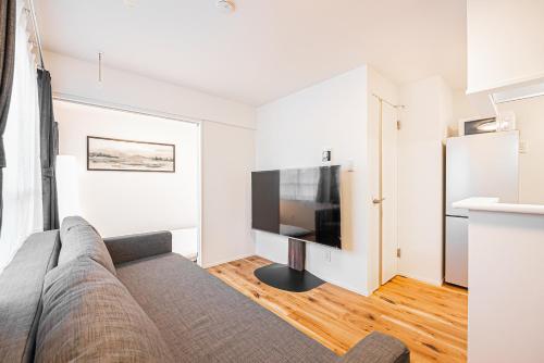 a living room with a couch and a flat screen tv at 67 Apt 板橋本町 in Tokyo