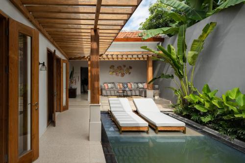 a pool in the middle of a house with benches at Gria Kerten in Solo