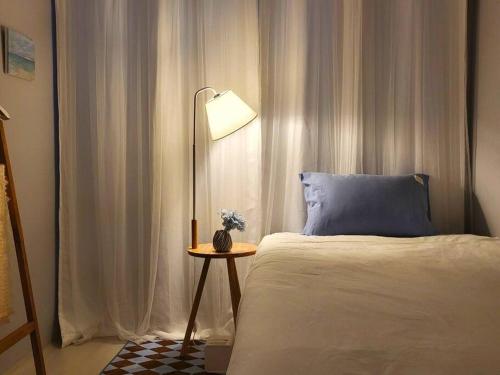 a bedroom with a bed and a table with a lamp at Ro-un house in Seoul