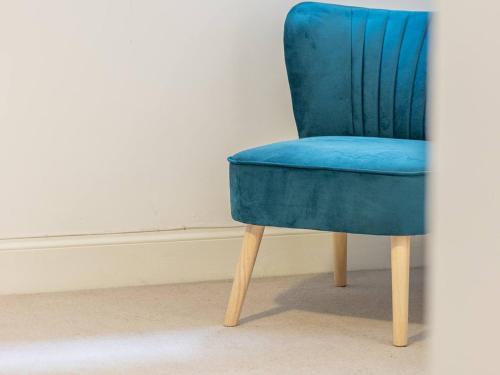 une chaise bleue assise dans une pièce dans l'établissement Pass the Keys Stylish West End Detached Mews, à Glasgow