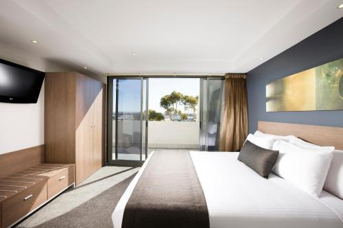 a hotel room with a bed and a tv at Mantra Melbourne Airport in Melbourne