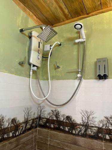 a shower in a bathroom with trees on the wall at Twilight Villas in Rattota