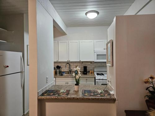 a kitchen with white cabinets and a counter top at Kona Mansions in Kailua-Kona
