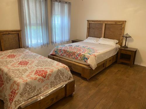 a bedroom with two beds and a wooden headboard at Rio grand country getaway in Harlingen