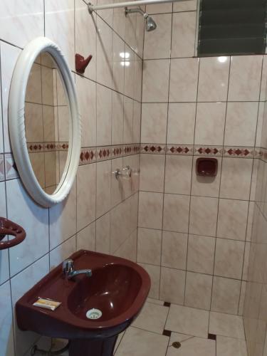 y baño con lavabo y espejo. en Hospedaje Del Carmen, en Machu Picchu