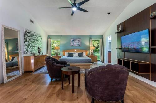a bedroom with a bed and a couch and chairs at Cozy home with big pool in Wellington! in Wellington