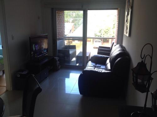 sala de estar con sofá y TV en Apartamento En Las Delicias, en Punta del Este